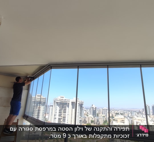 אדם מתקין וילון על חלון גדול במרפסת